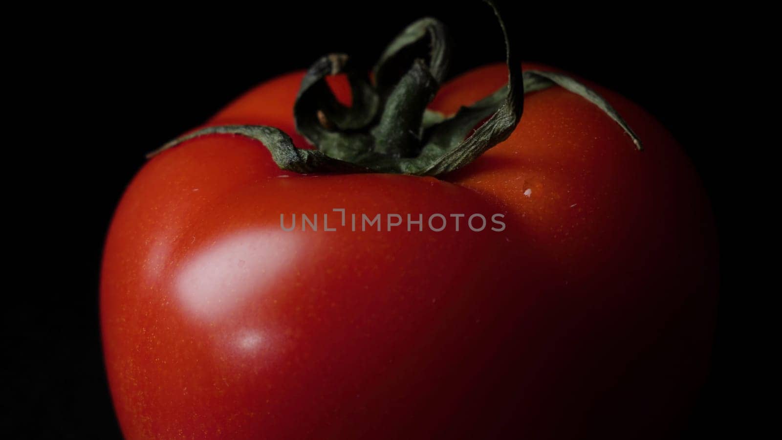 Close up of red juicy tomato on black background. Frame. Food concept.