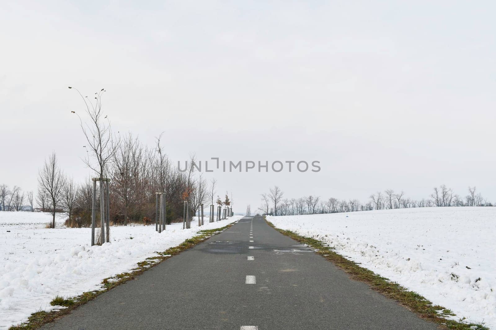 Road raked by snow plough in winter. Roads cleared by plough in winter. Concept of winter and winter road care by roman_nerud