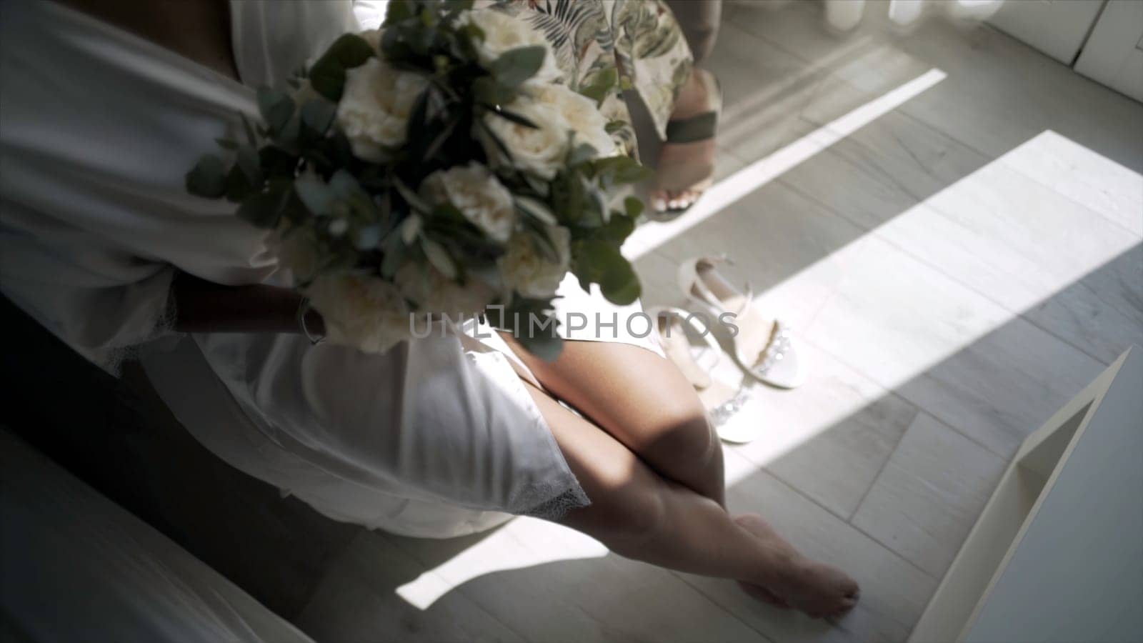 Stylists prepare elegant bride for wedding ceremony. Action. Beautiful bride is preparing for wedding ceremony. Exciting and happy moments of preparing bride for wedding.