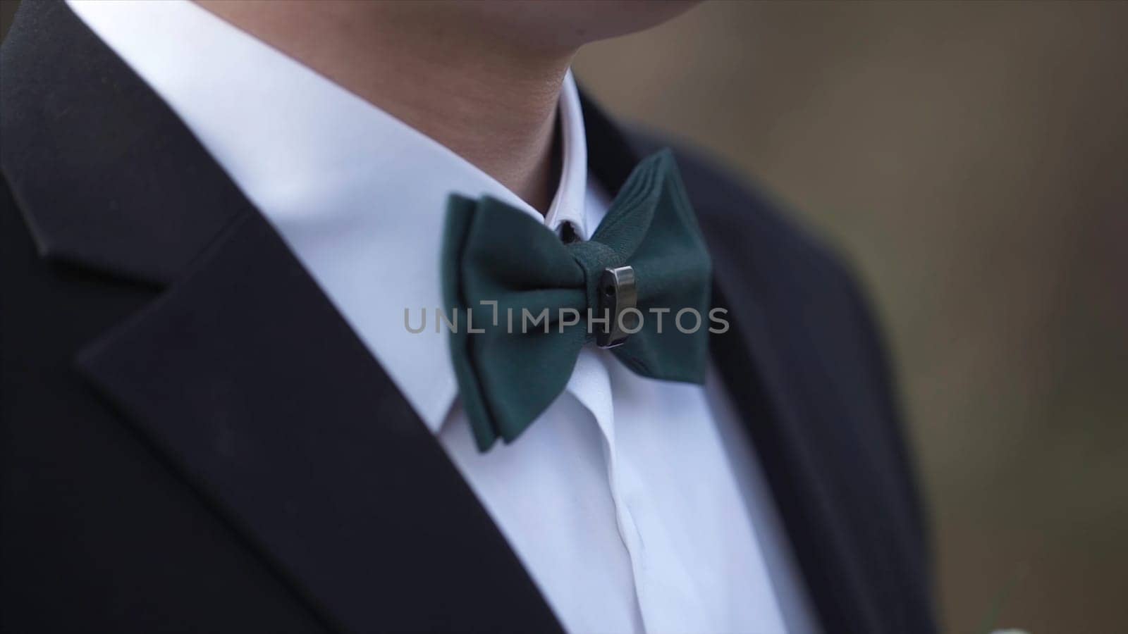 Close-up on nerd, man in bow tie. Man's hands touches bow-tie on a suit or tuxedo. man in a shirt and bow tie closeup