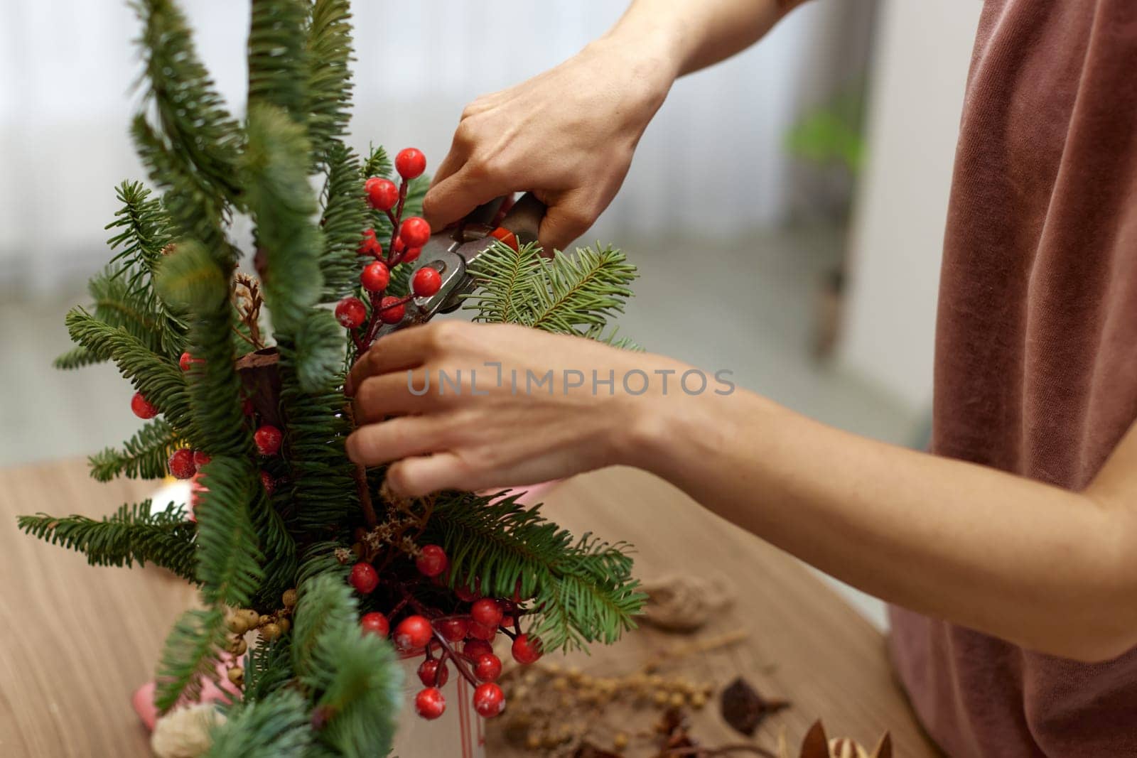 Woman making Christmas arrangement with fir branches. craft handmade decor.