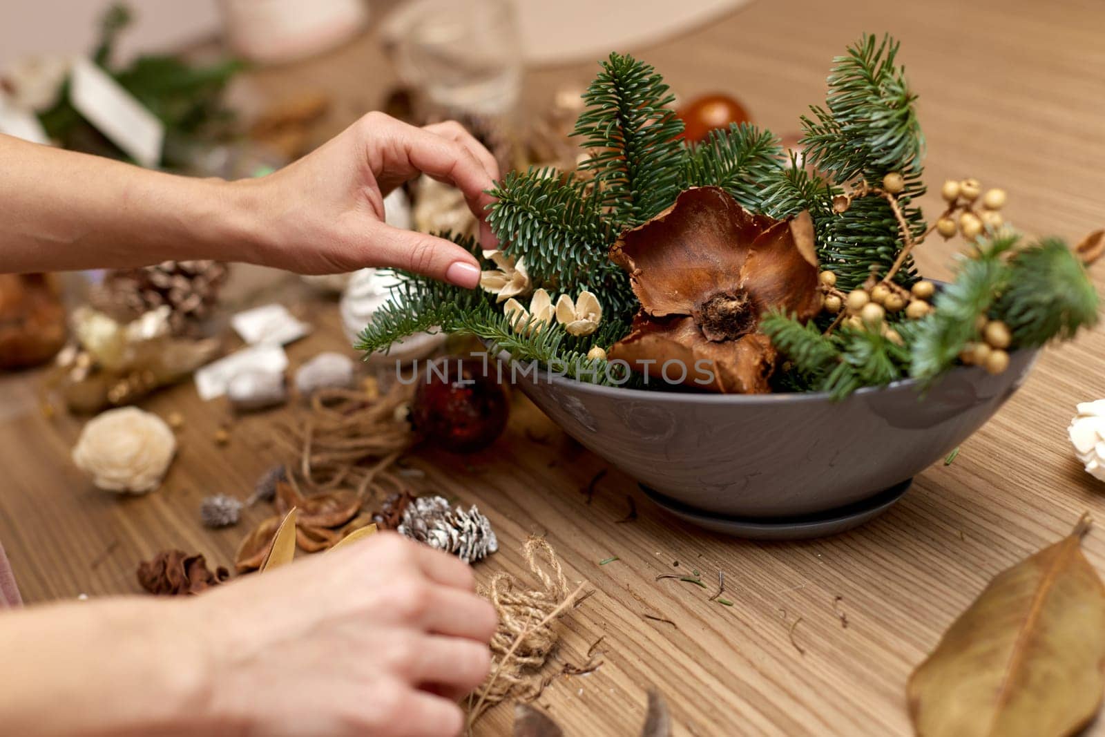 Woman making Christmas arrangement with fir branches. craft handmade decor.