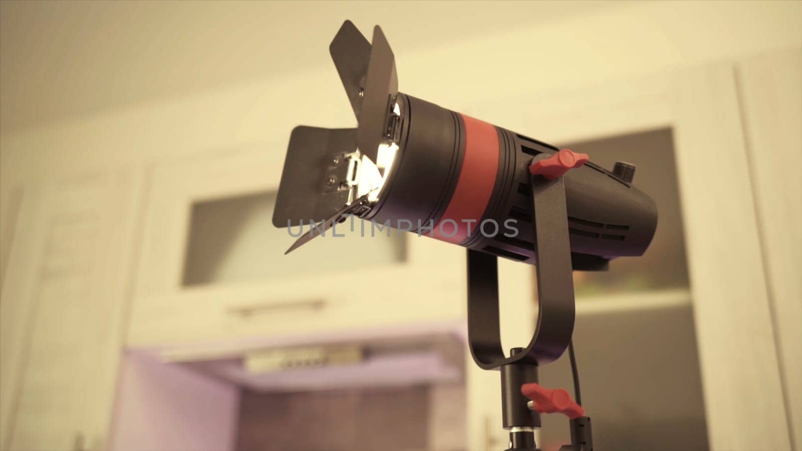 Modern LED spotlight for indoor lighting during photo or video shooting. Close up of glowing illuminator indoors, concept of professional equipment.