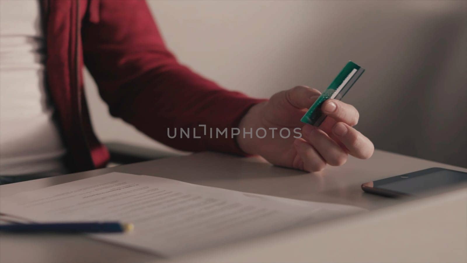 Online payments concept. Stock. Business man holds a credit card in his hand while using or typing identification numbers after buying goods from retailer stores via the internet.