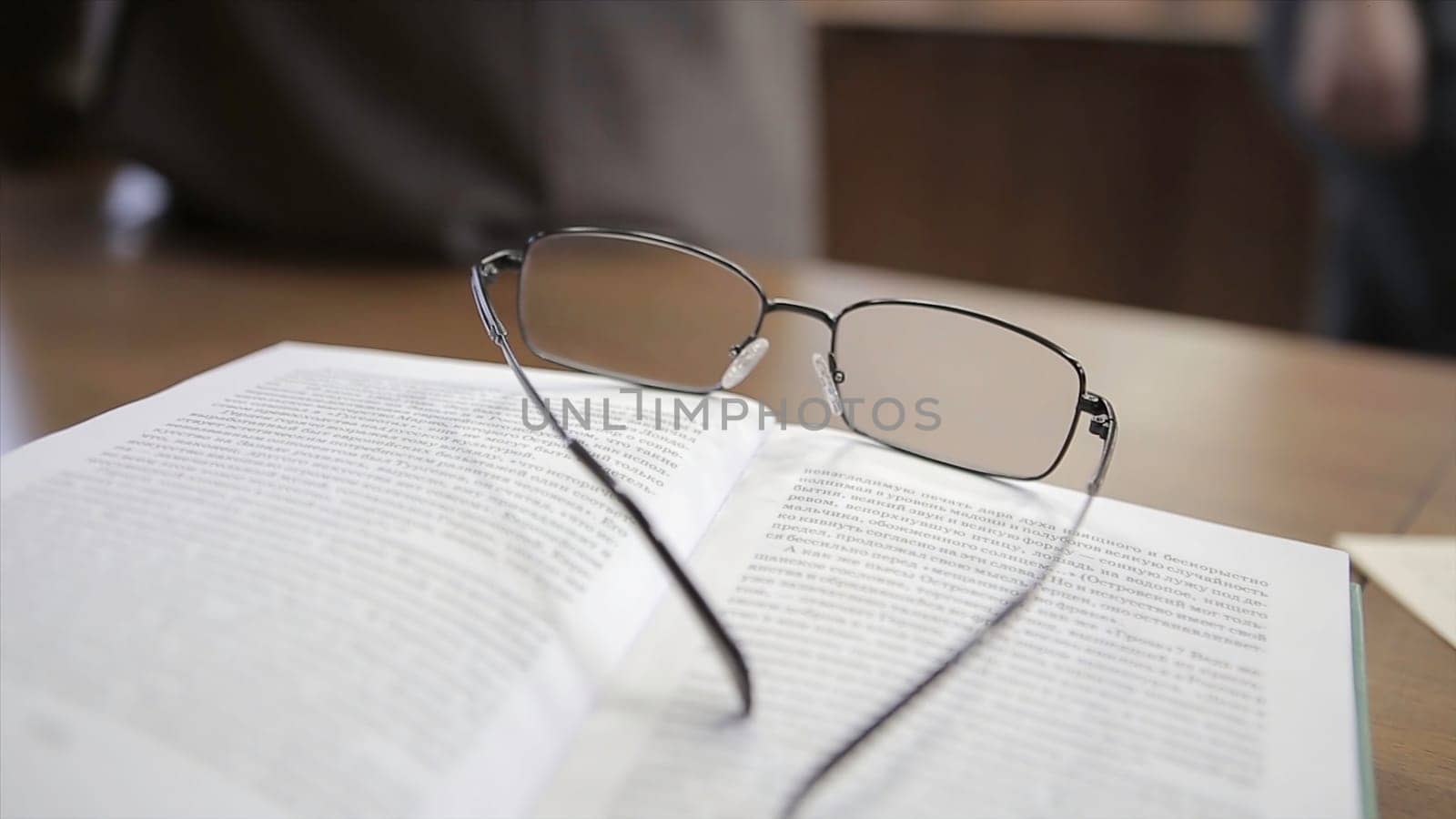 White notebook with glasses on wooden table. Glasses teacher on the table.