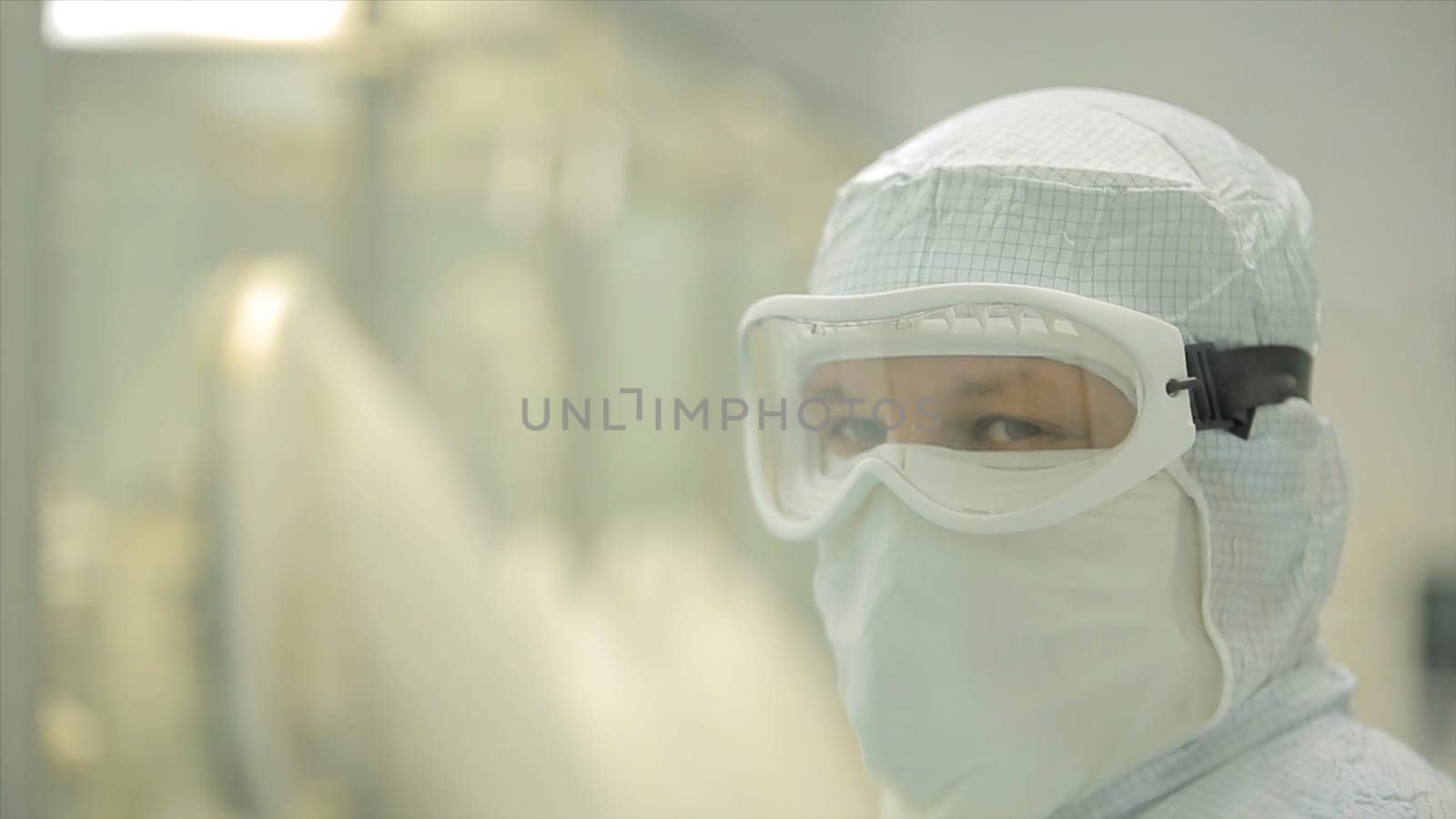 Pharmaceutical industry. Male factory worker inspecting quality of pills packaging in pharmaceutical factory. Automatic tape to create packaging and filling of medicines. control in the factory of medicine HD