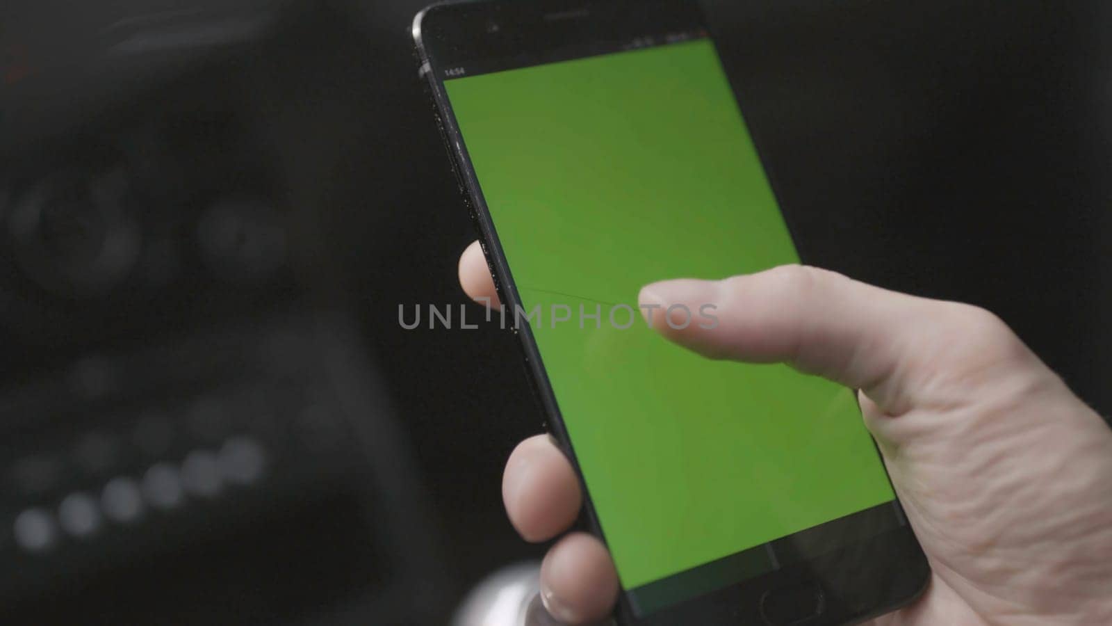 Close-up of man tapping on green phone screen. Stock. Man tapped green screen of phone to view map and removed it. Man looks at green screen of phone as if it's map.