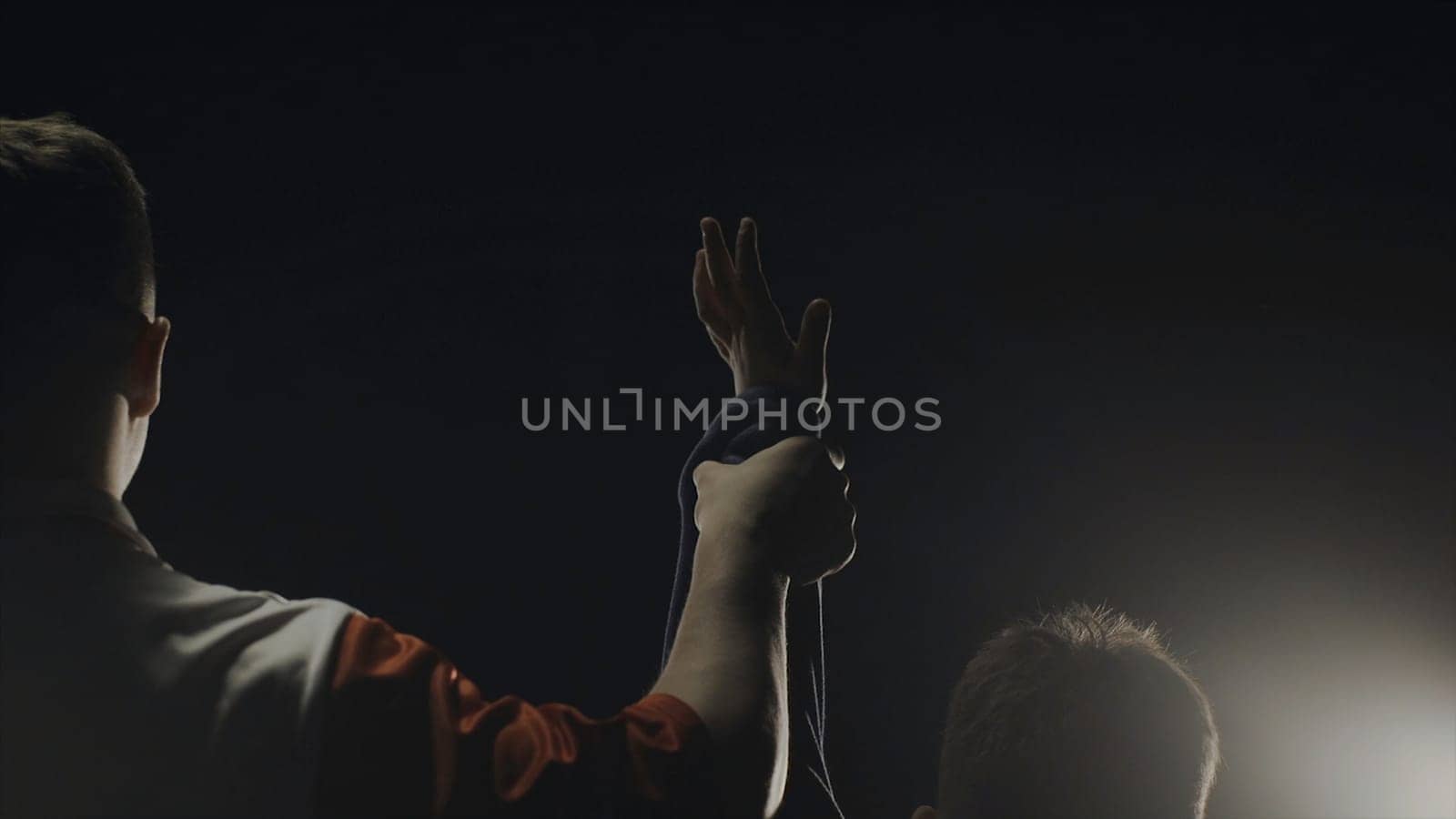 Rear view of the referee who raises the winner's hand. The referee raises the hand of the boy winner in the ring.
