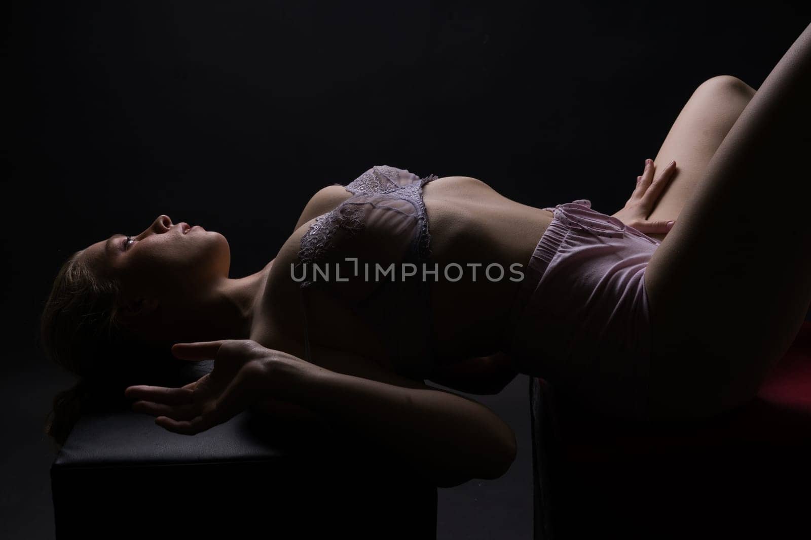 Low key portrait of beautiful female body on a dark background