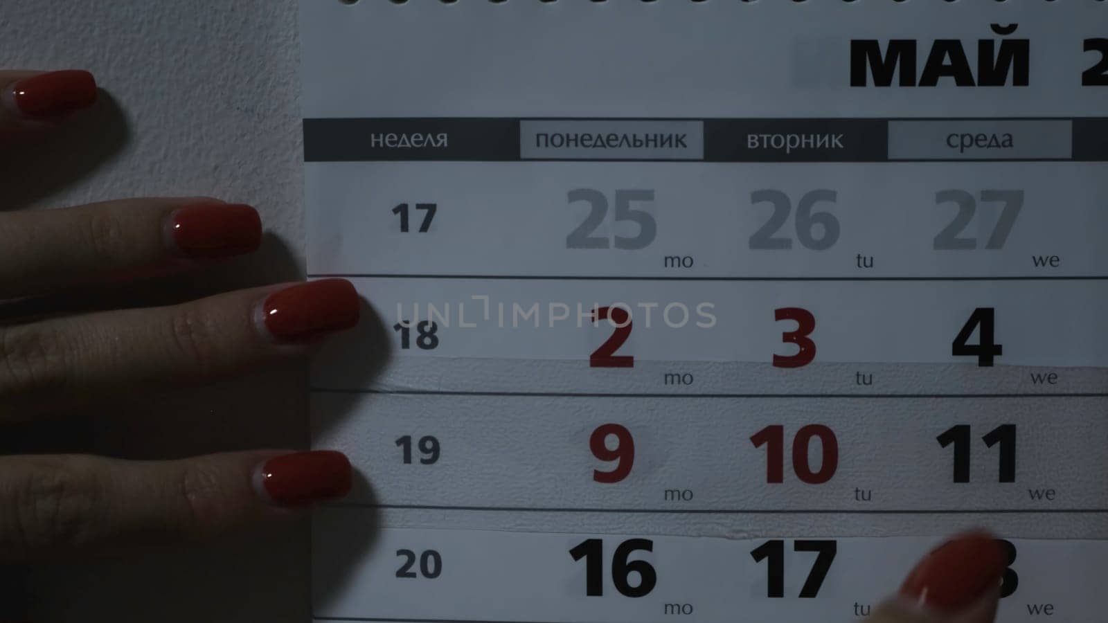 Woman moving date on calendar. Concept. Woman moves calendar slider. Woman marks new day of week on calendar.