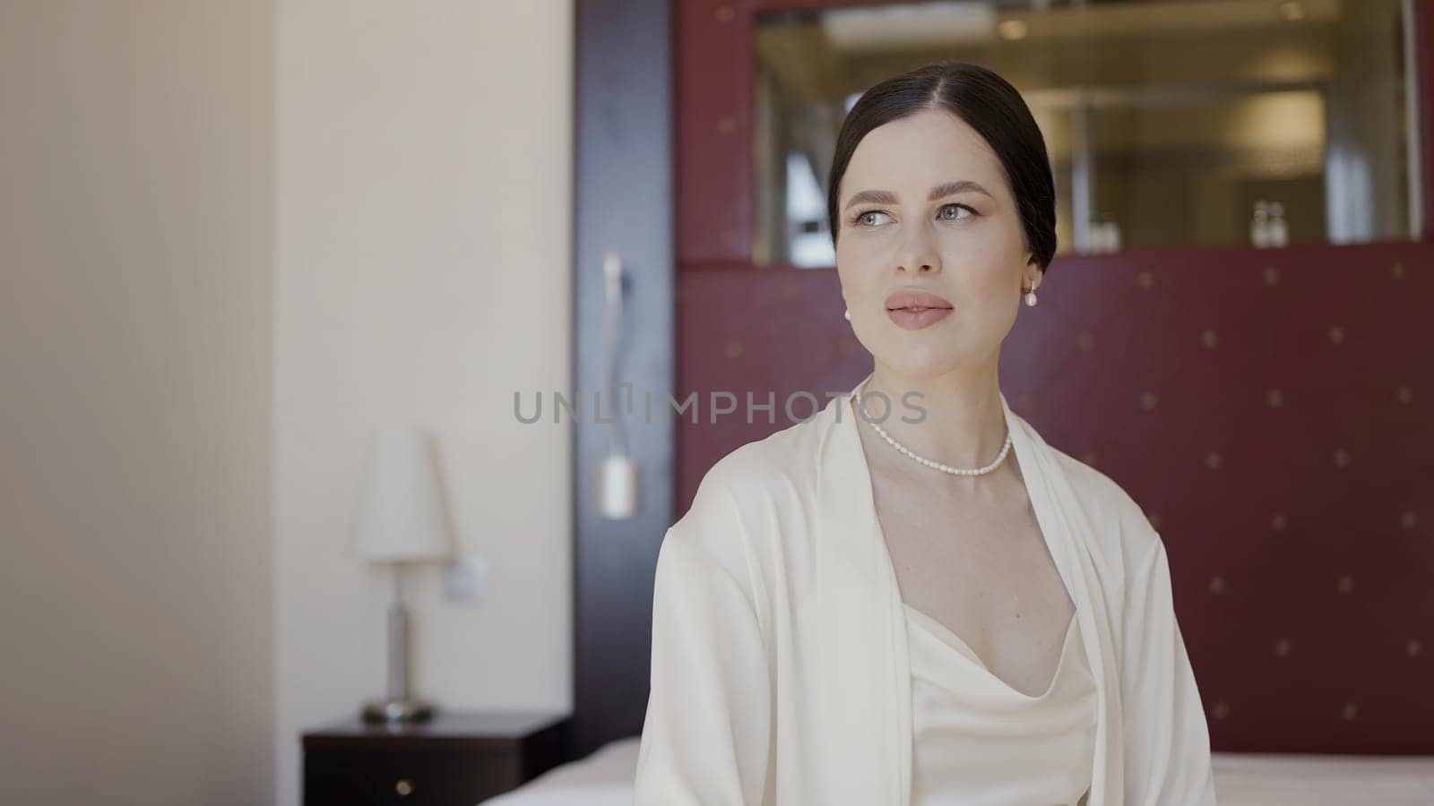 Posing cute model with calm makeup. Action. Posing a model in an apartment with a bright street light. by Mediawhalestock