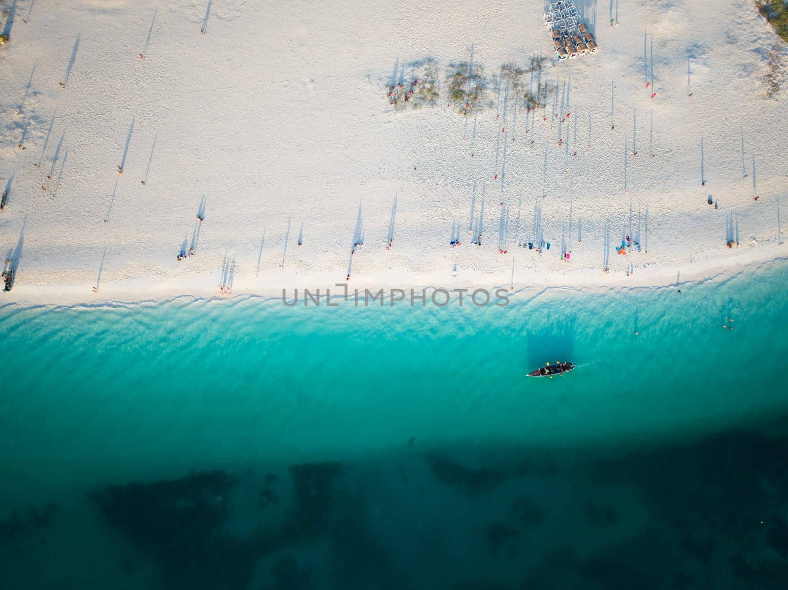 Birds view of dhow boat in the green ocean and wonderful white sandy beach, copy space, Zanzibar in Tanzania.