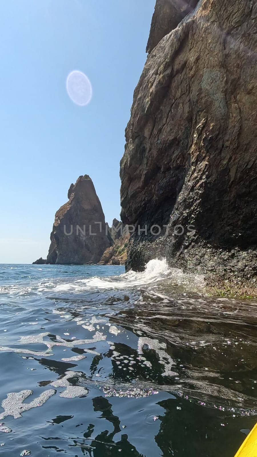 Sea kayak rocks waves. Kayaking in the sea on a sunny day along the coast and rocks. vertical video
