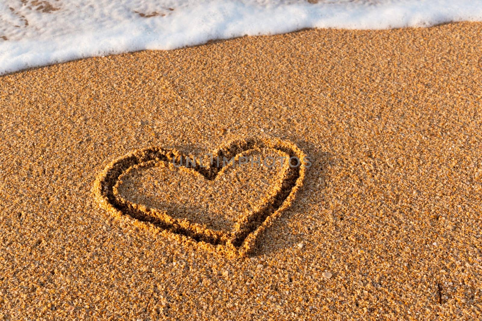 heart is drawn on the sand on the beach during the day. Heart shape. Heart symbol. Love. Sea foam by yanik88