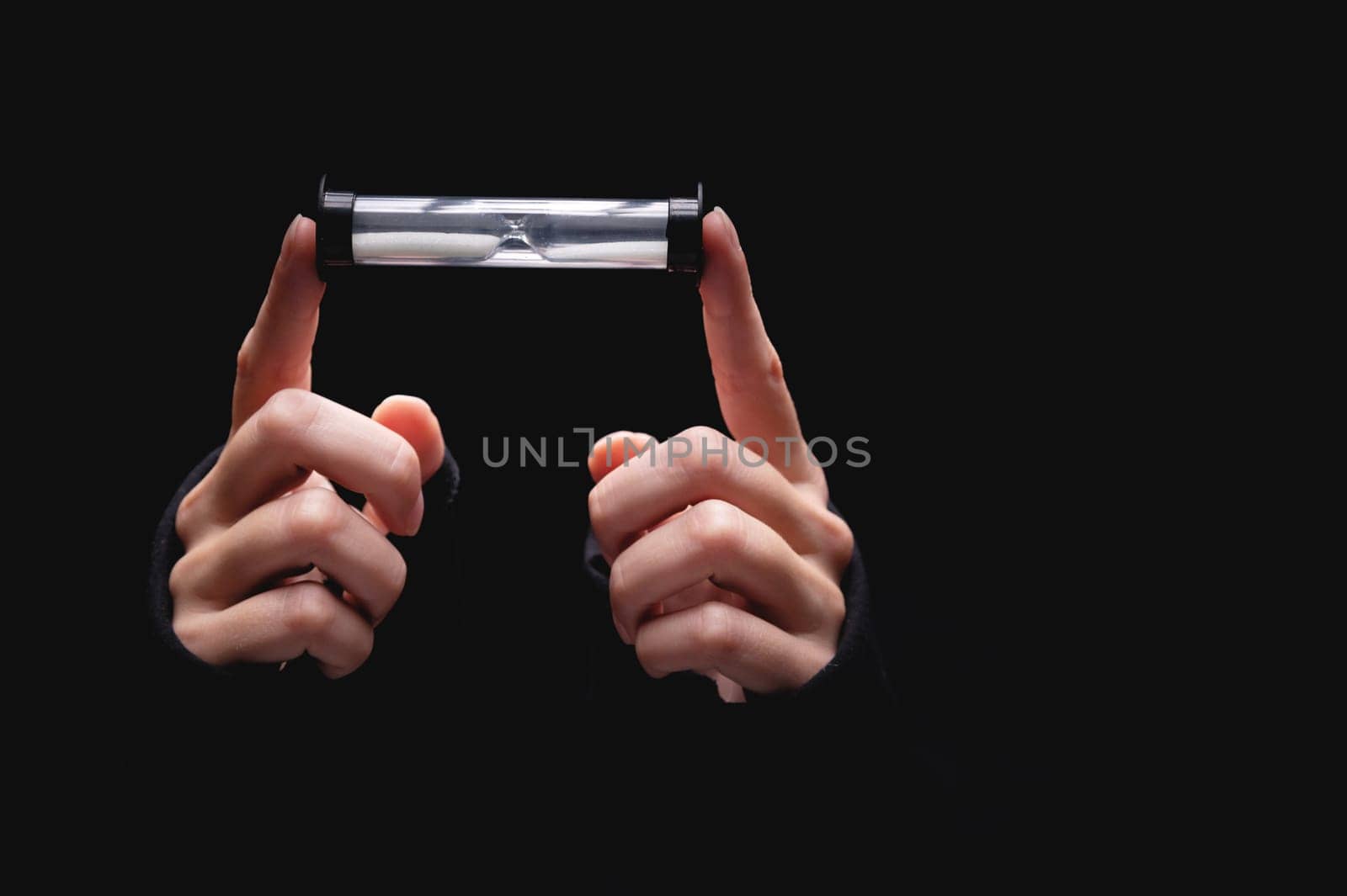 conceptual image of a man holding an hourglass. concept of deadline and schedule or stopping time and averaging.