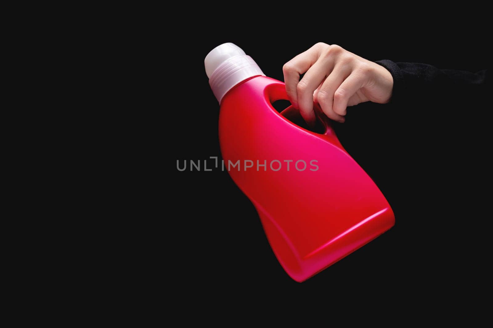 Using a chemical bottle. Female hand holding bleach or liquid laundry detergent, empty container for label advertising.