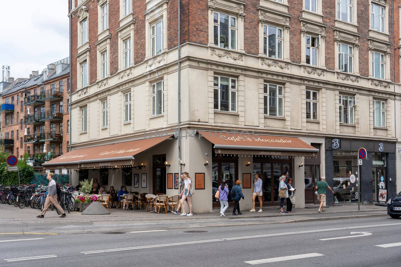 Copenhagen, Denmark - June 30, 2023: People at a corner cafe in Frederiksberg district.
