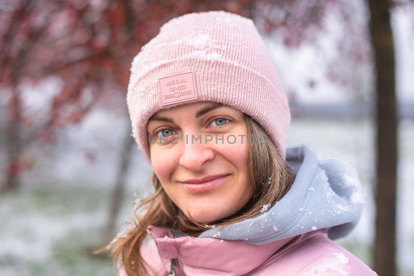 Winter Elegance: Portrait of a Beautiful Girl in a Snowy European Village. Winter lifestyle portrait of cheerful pretty girl. Smiling and having fun in the snow park. Snowflakes falling down. Christmas Radiance: Capturing Winter Elegance in the Snowy Ambiance of a European Village by Andrii_Ko