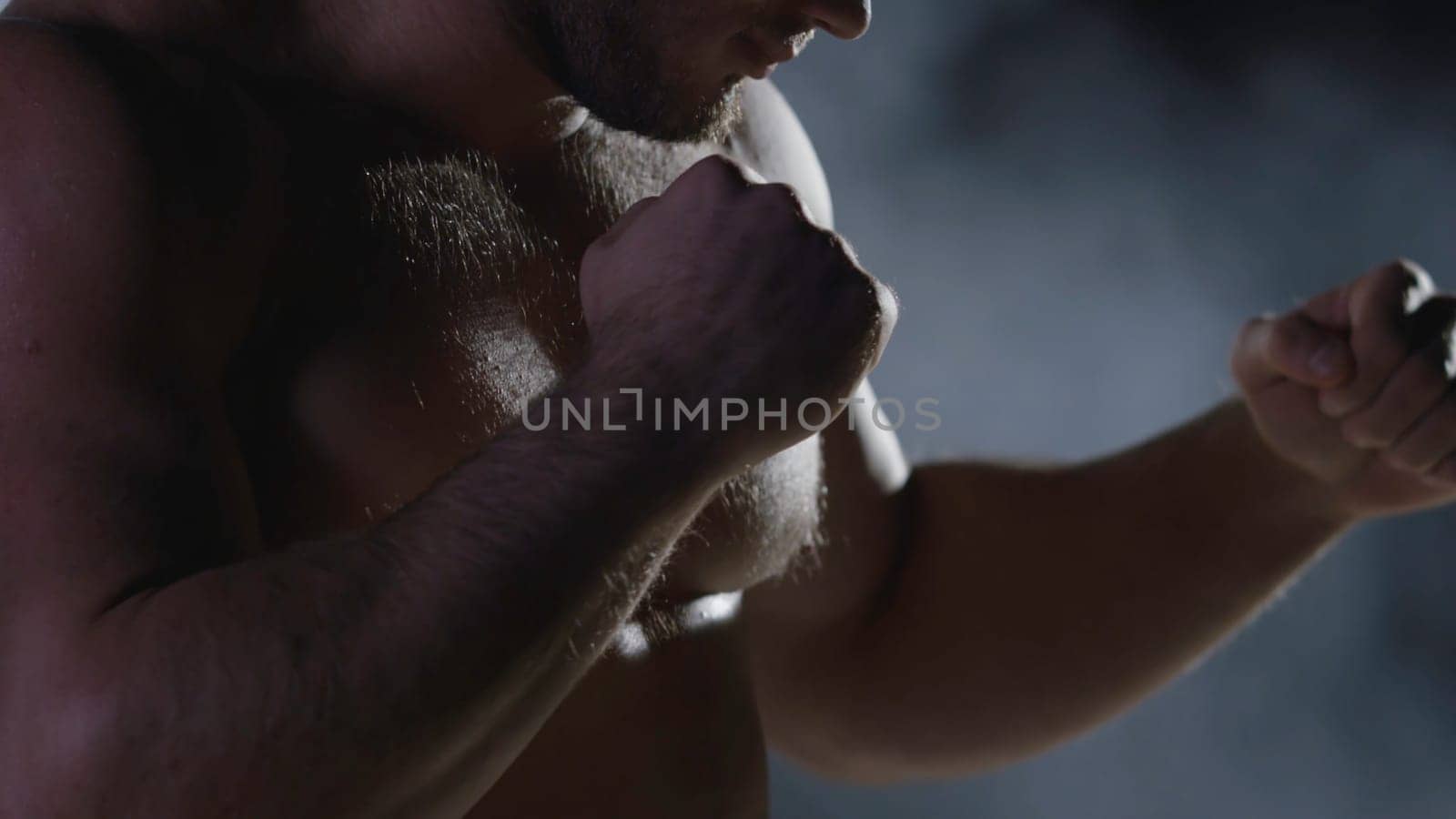 Boxing man ready to fight. Boxer with strong hands and clenched fists on a black background. Close-up of hand of boxer ready for a fight