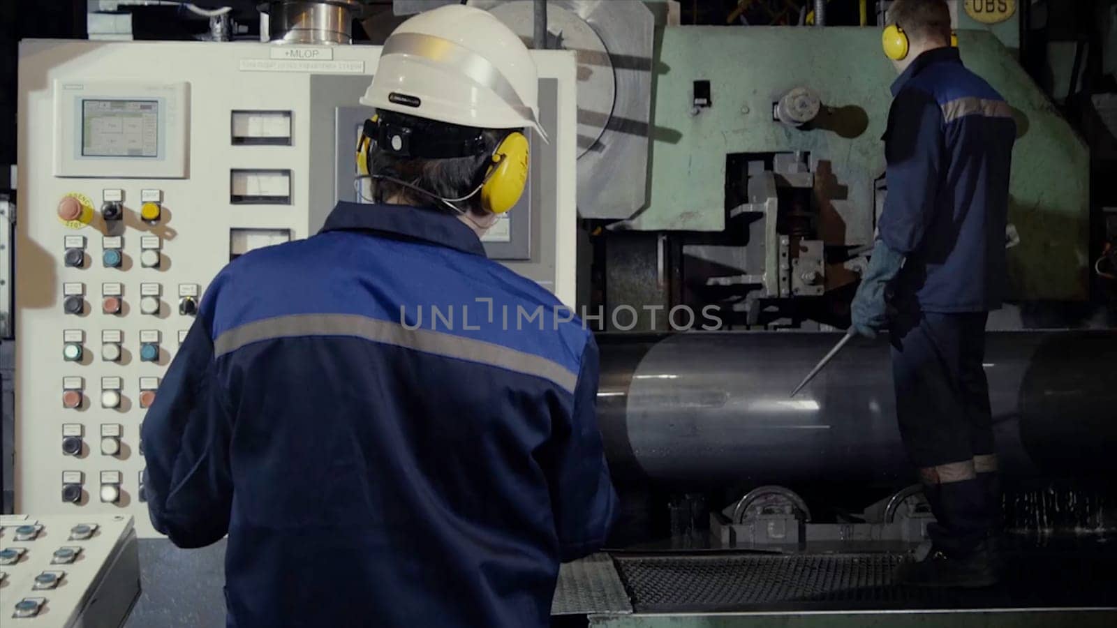 Two workers in production plant as team discussing, industrial scene in background. two worker in factory on the machine. Worker with out safety equipment caught in the machine HD