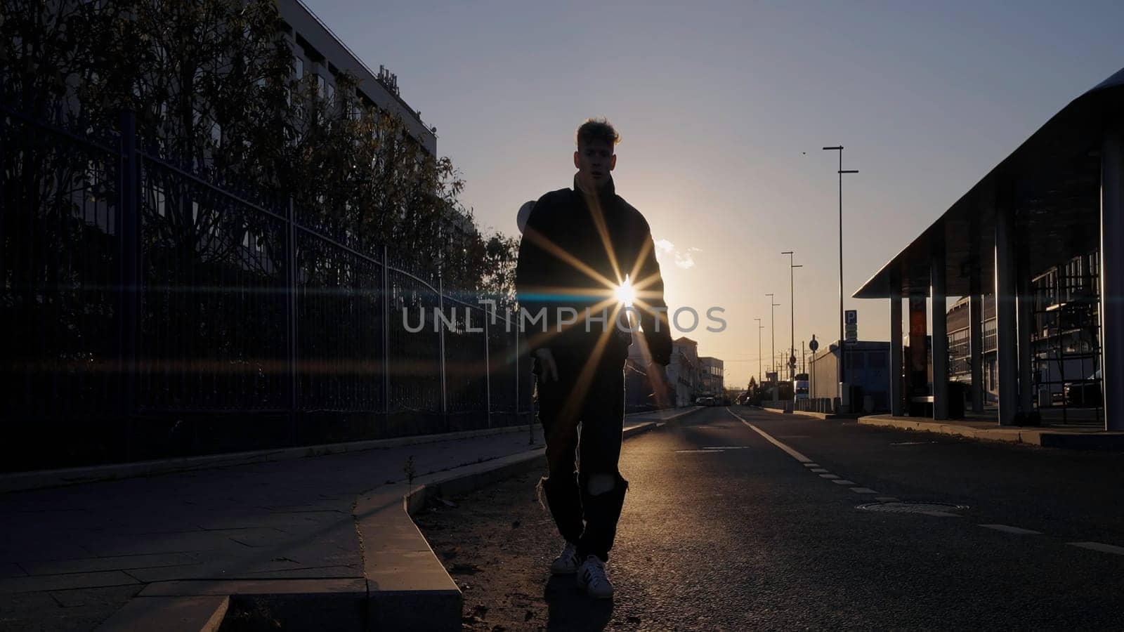 Dancing man in the street with sunset behind. Action. Young man dancing alone outdoors