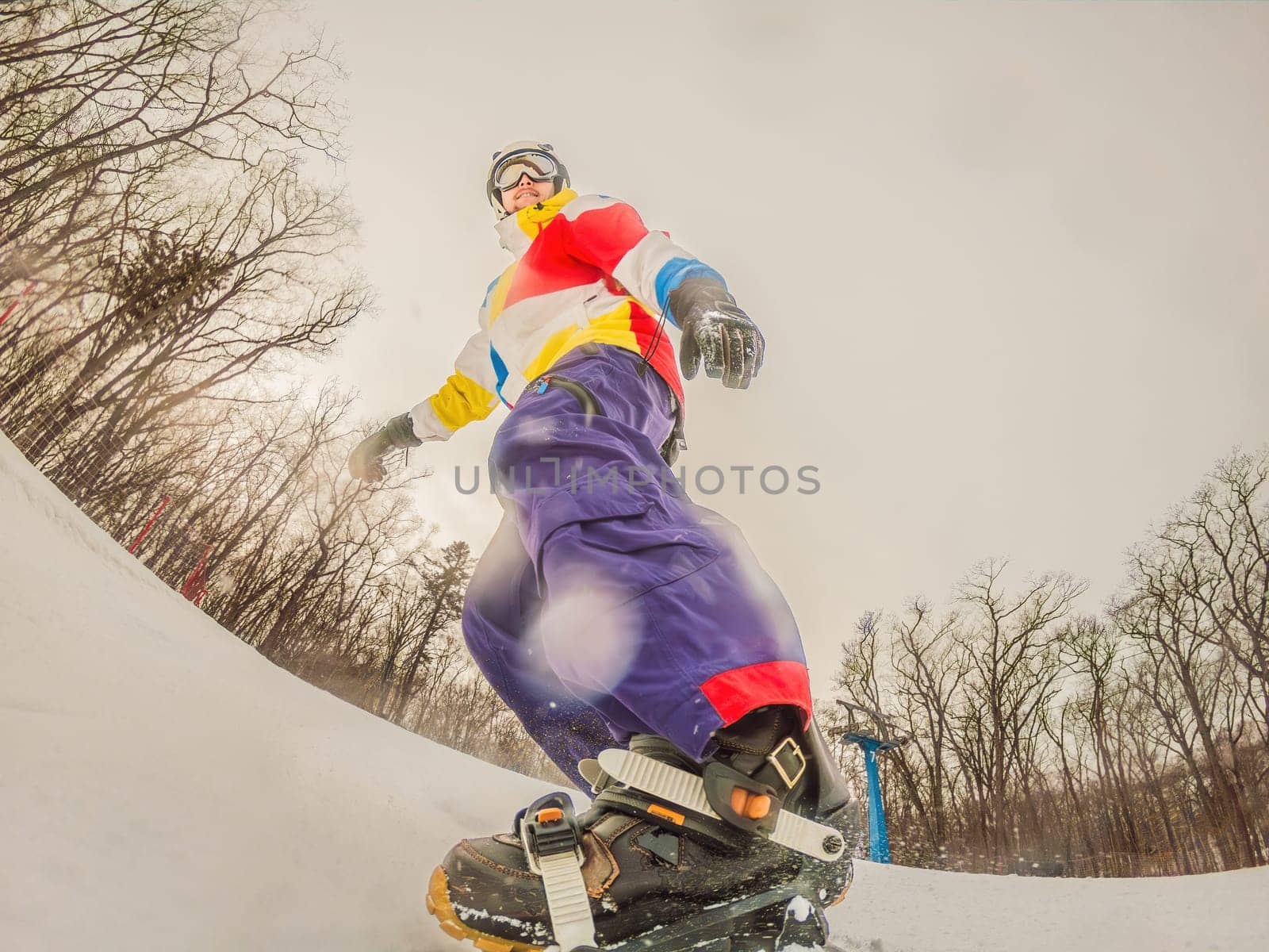 A daring man conquers snowy slopes with style, showcasing skill and thrill as he maneuvers on a snowboard, capturing the essence of winter adventure by galitskaya