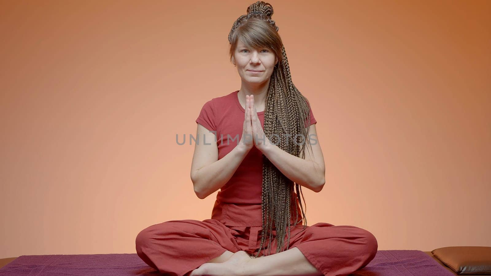 A meditating girl. Action.A young girl with afro-curls is sitting on a rug and doing yoga. High quality 4k footage