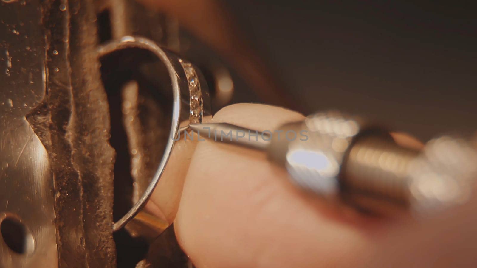 The jeweller is setting a precious stone. Craft jewelery making. Ring repairing. Putting the diamond on the ring. Macro video. Craft jewelery making with professional tools. Putting the diamond on the ring. Macro photo.