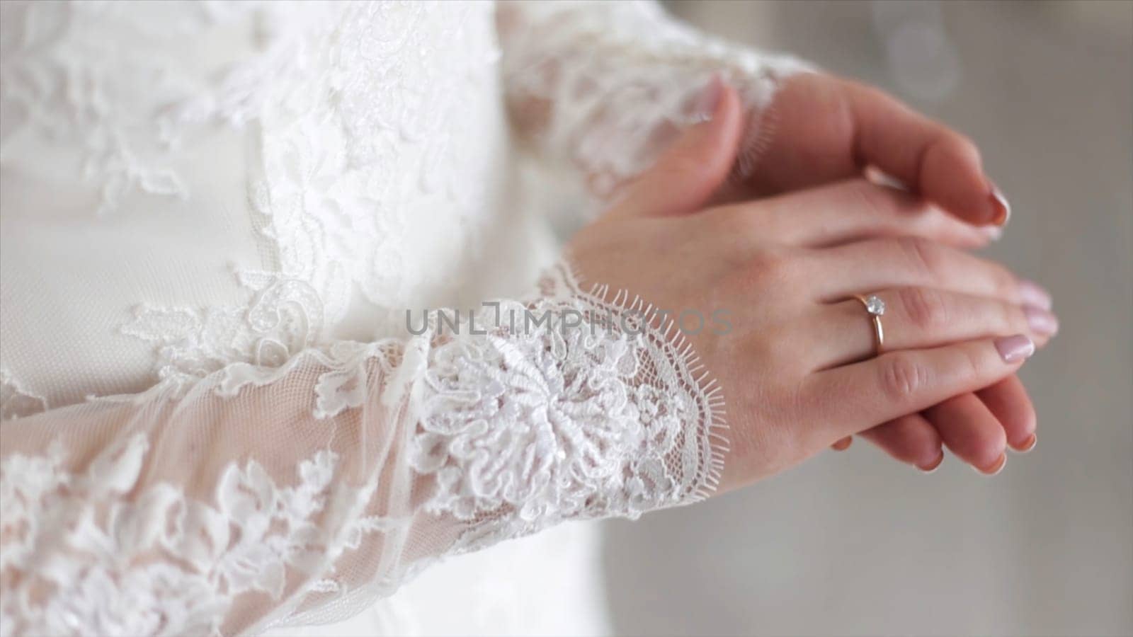 Close up of elegant ring on the finger. Soft and selective focus. Close-up of tender ring on bride's hand with white nails.
