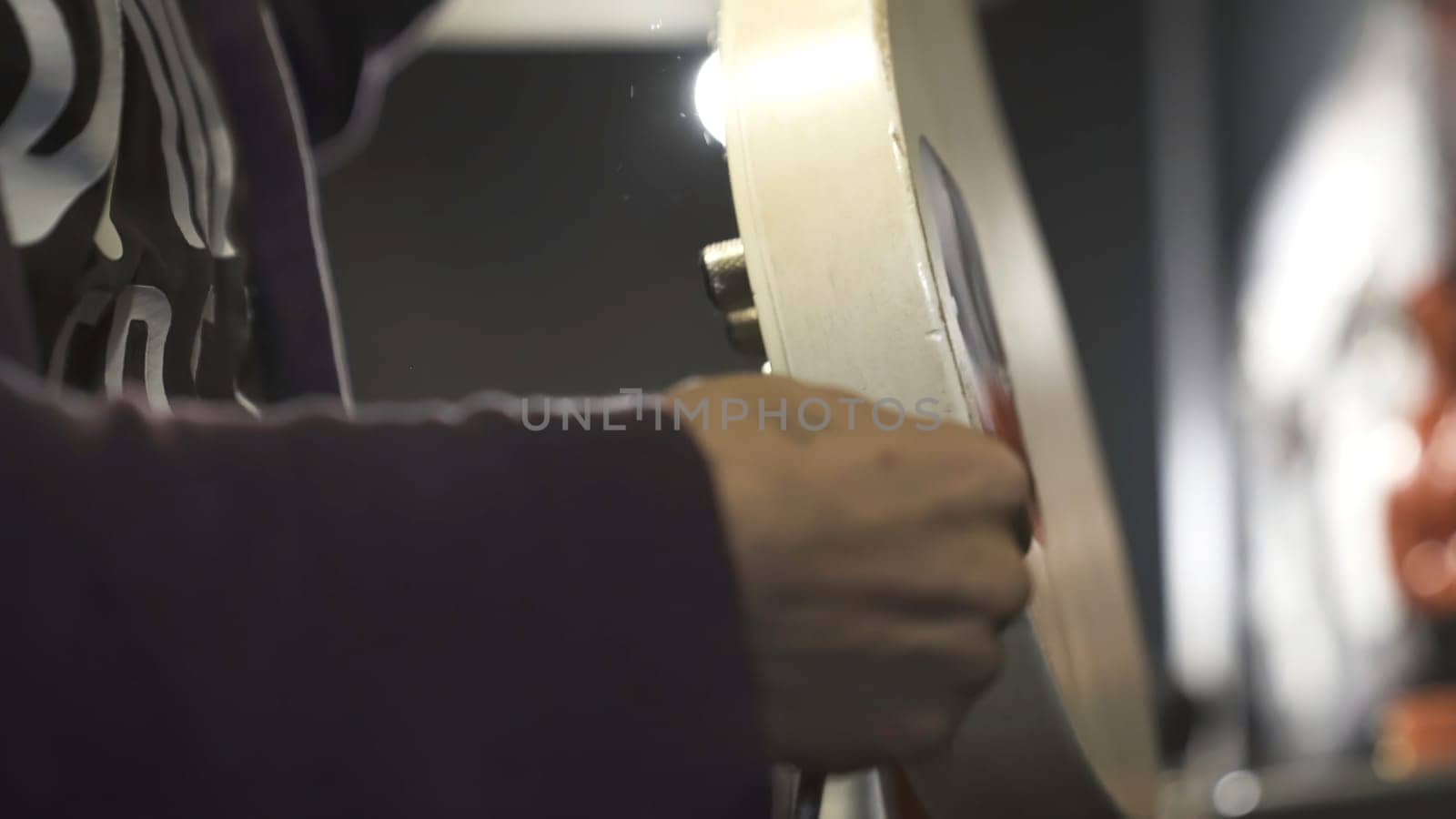 Close up of a man putting jack cable into electric guitar. Male musician holding white electric guitar and audio jack cable on blurred background, music concept.