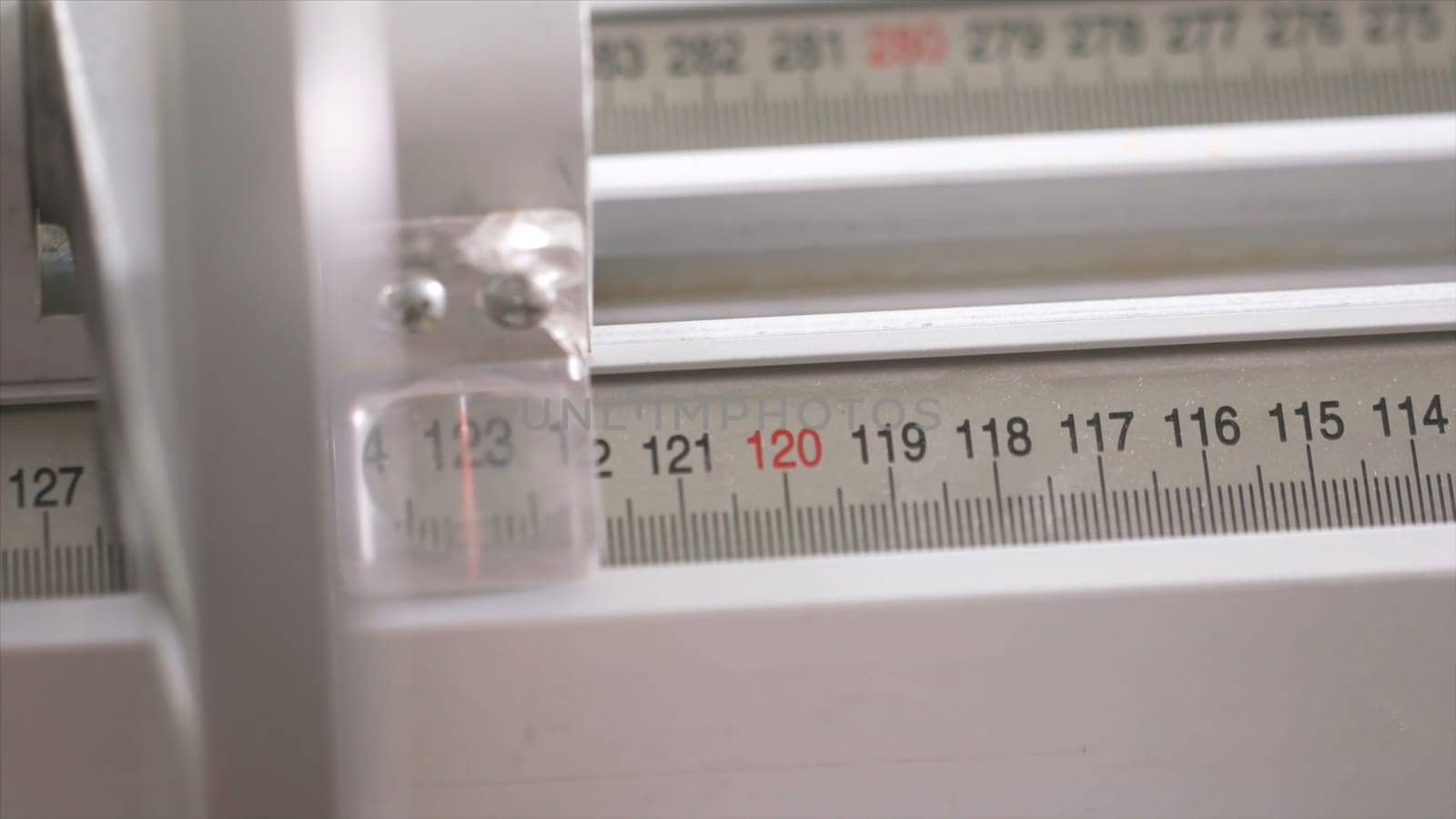 Close-up of worker of furniture factory measuring a wooden block with industrial measuring device. Production, manufacture and woodworking industry concept