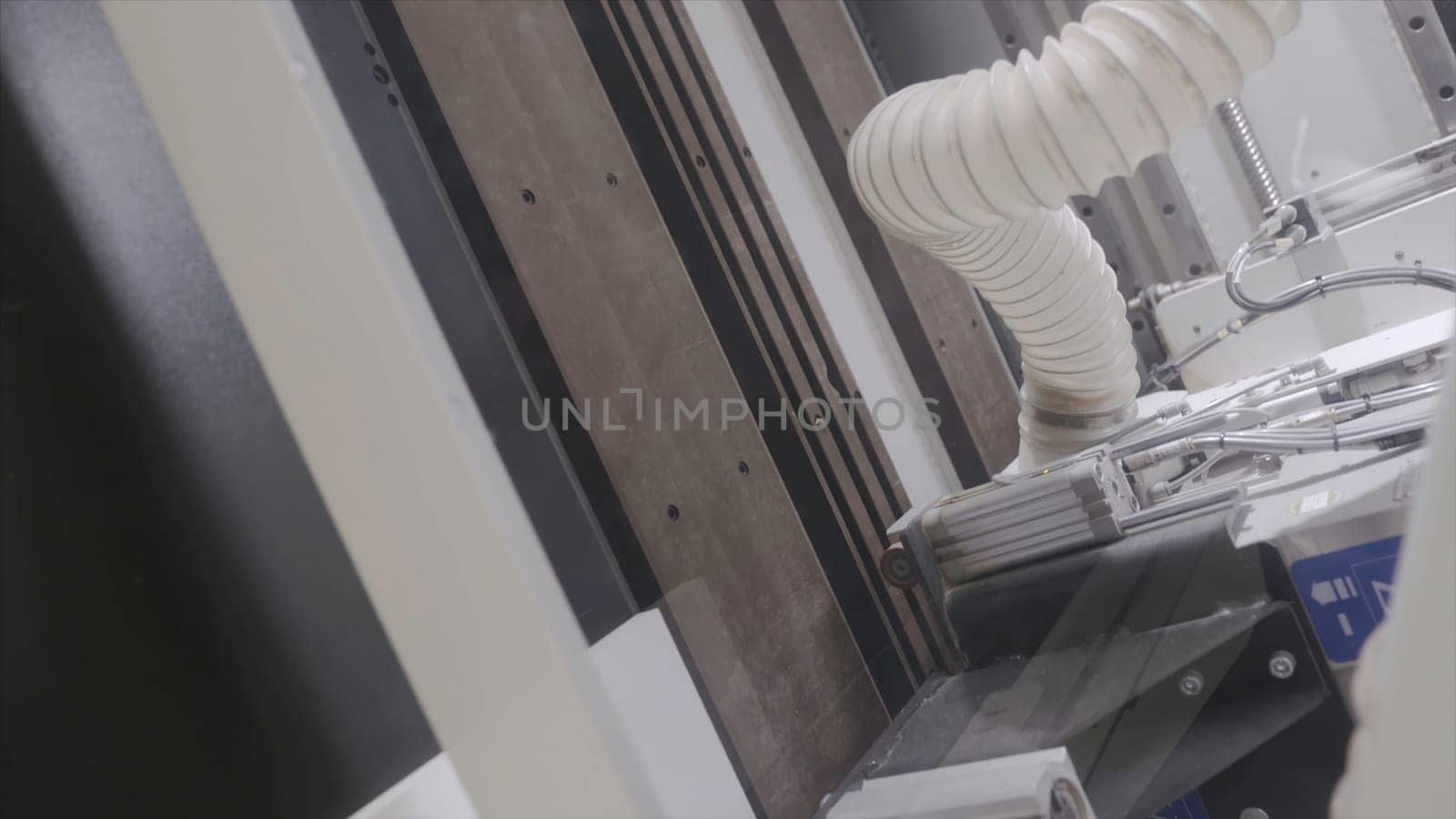 Modern machine making cuts on wooden boards. Action. Professional equipment at woodworking enterprise. Large multitasking machine working with wooden products.
