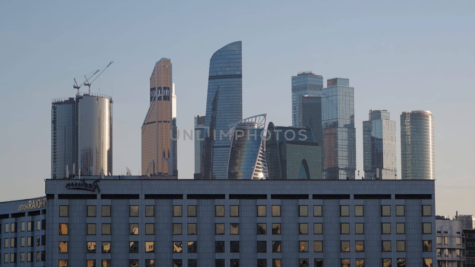 Beautiful view of modern high-rises on sunny day. Action. Beautiful view of center with modern glass skyscrapers. Center with high-rise buildings on blue sky background on sunny day.