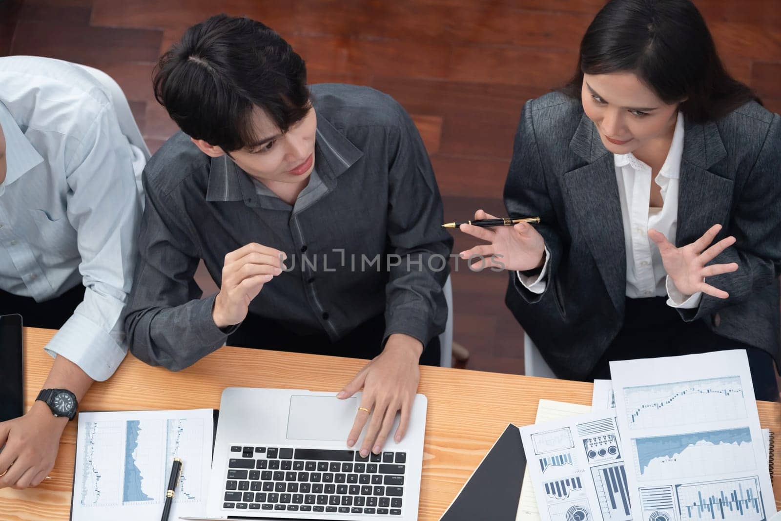 Top view multiracial analyst team use BI dashboard data to analyze financial report on meeting table. Group of diverse business people utilize data analysis by FIntech for business decision. Concord