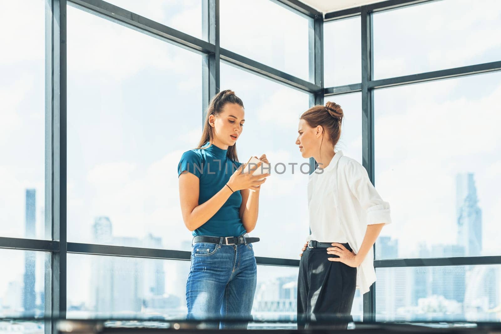 Portrait of young beautiful professional architect engineer team discuss about house design. Skilled businesswoman brainstorming and sharing marketing ideas surrounded by skyscraper. Tracery.