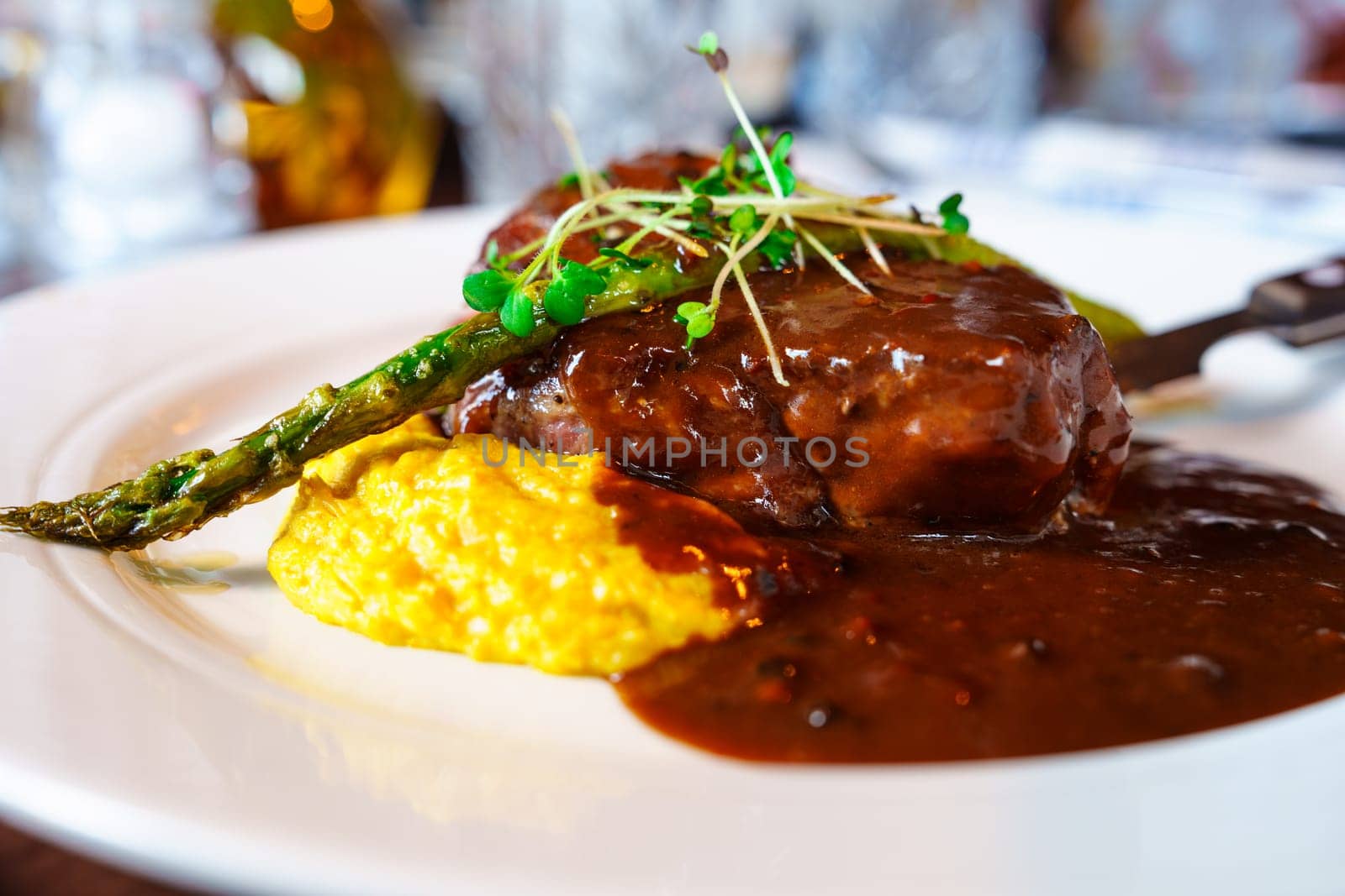 Delicious Steak with Mashed Potatoes and Asparagus Served with Sauce on White Plate by PhotoTime