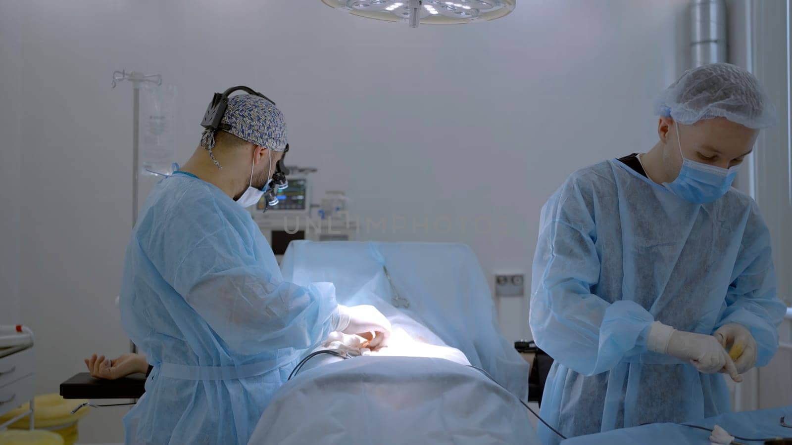 Two male surgeons in a special uniform performing medical procedure. Action. Concept of healthcare and medicine