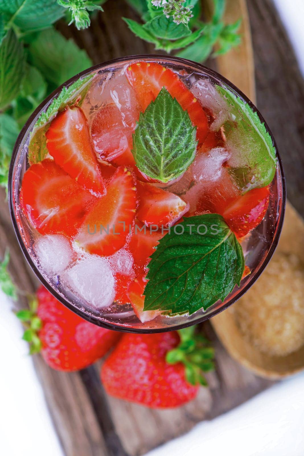 cocktail with fresh strawberries, mintand ice cubes over old white wooden table. by aprilphoto