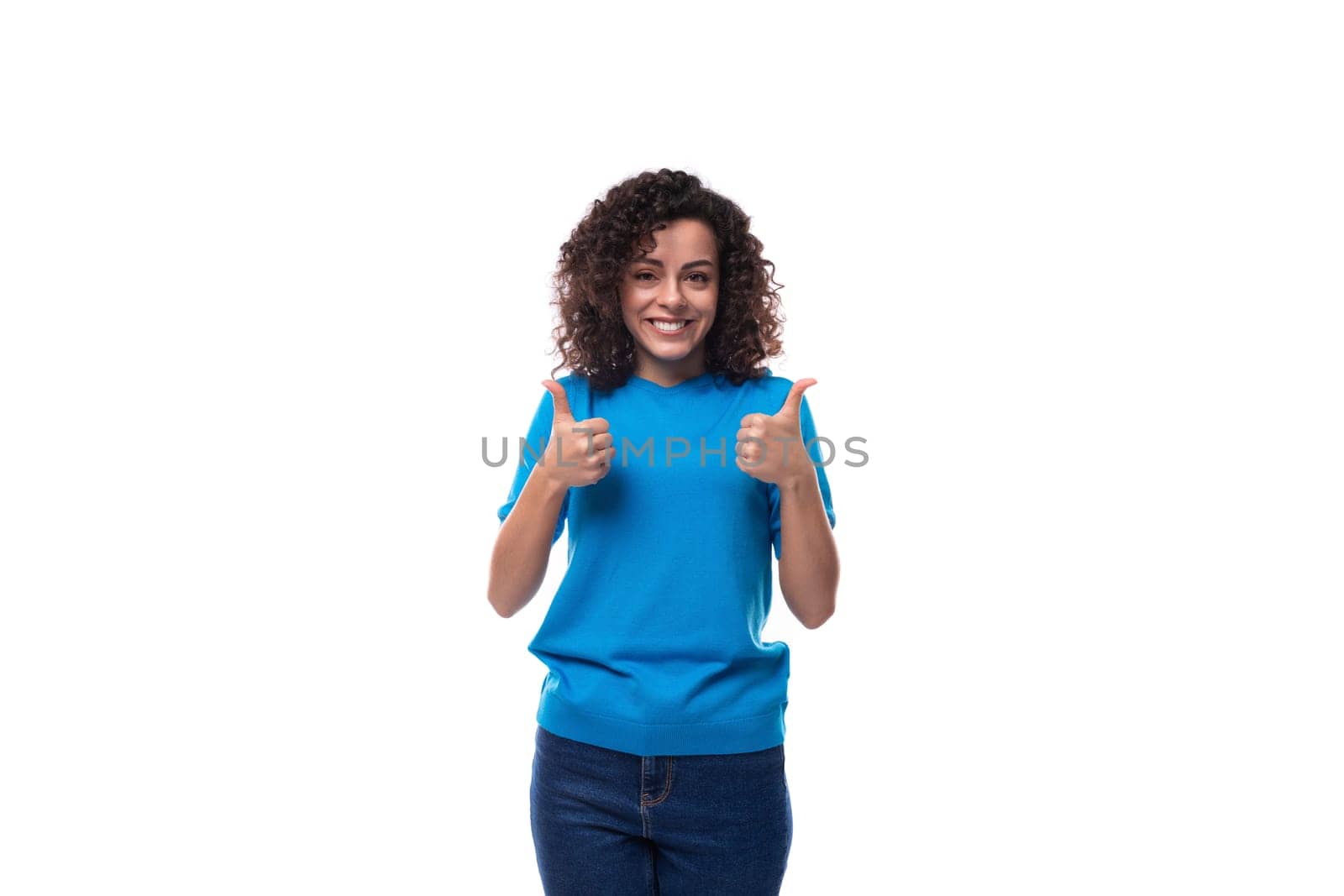 young happy woman with curly black hair dressed in a blue t-shirt.
