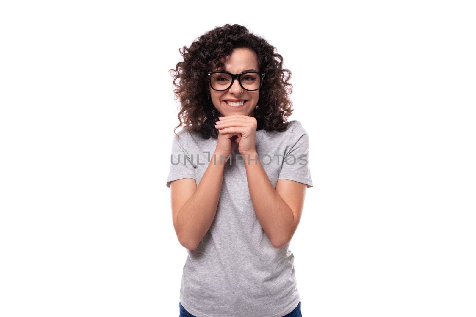 well-groomed cheerful energetic young european slim brunette woman with curly hair styling on a white background with copy space.