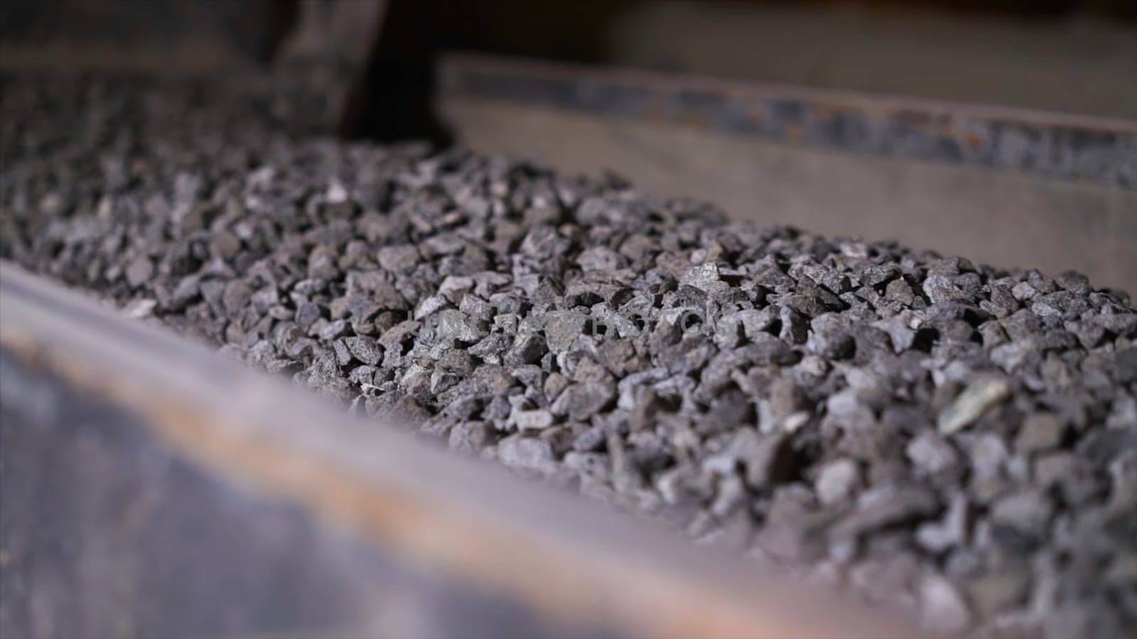 Minerals moving on conveyor belt in factory. Stock footage. Crushing and processing plant of minerals. Stone ore on conveyor plant factory.