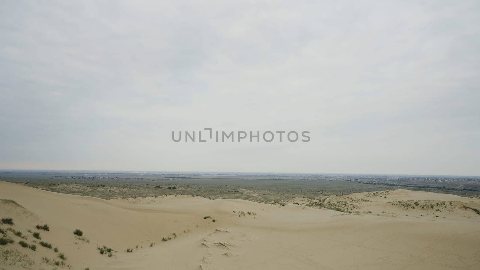 Beautiful desert mountains. Action. The desert against the white sky behind the big slightly green mountains and all in the sand