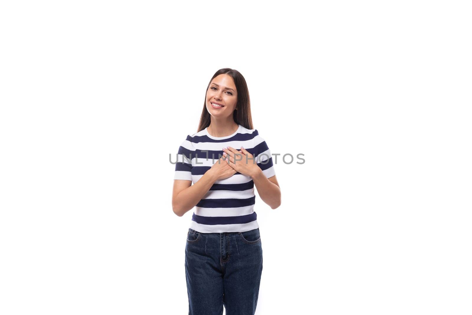 a young kind brunette caucasian woman with a light make-up dressed in a striped t-shirt and jeans wins over with a smile.