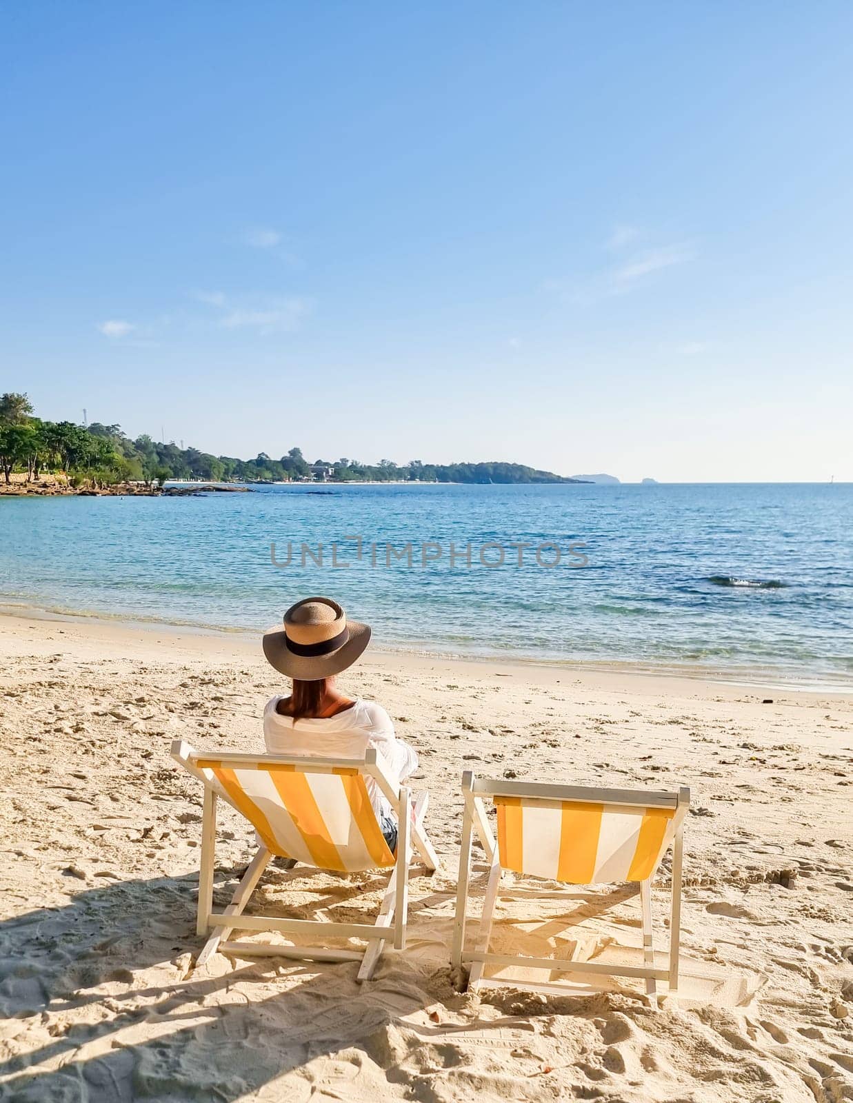 Asian woman on a beach chair on the beach of Koh Samet Island Rayong Thailand, the white tropical beach of Samed Island with a turqouse colored ocean