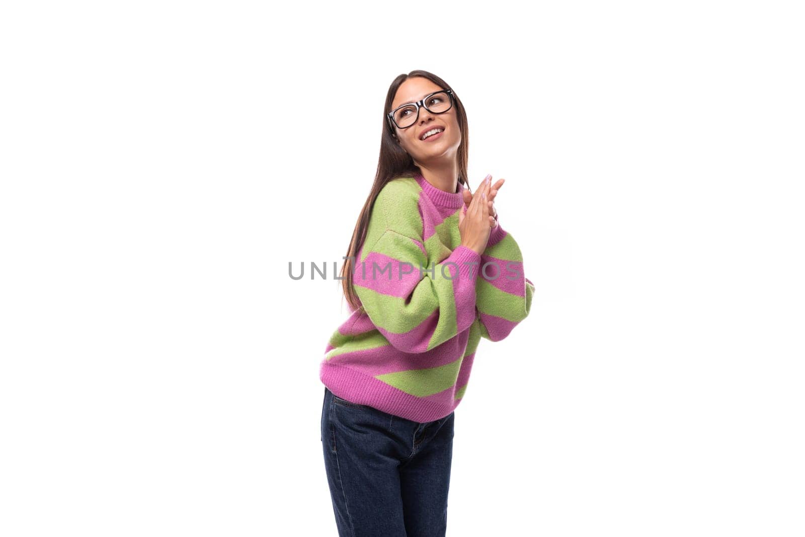 portrait of a smart young brunette woman in a casual stylish pink-green sweater with glasses for vision on a white background with copy space.