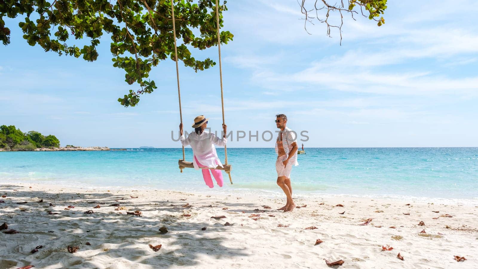 A couple of men and woman at a swing on the beach of Koh Samet Island Rayong Thailand by fokkebok