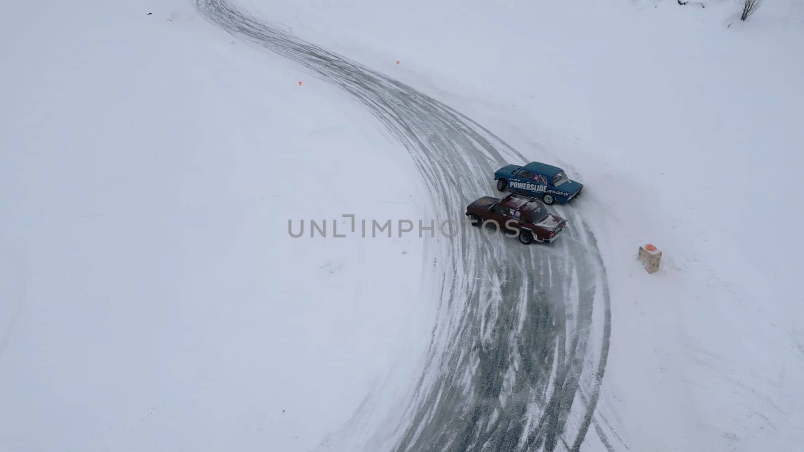 Winter fun filmed from a helicopter. Clip. Winter drift in cars that go to competitions and people watching around. High quality 4k footage