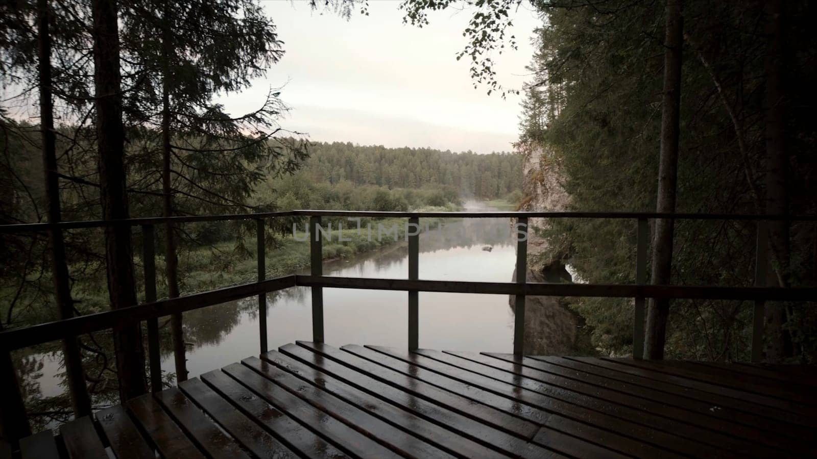Landscape with river flowing in forest area in cloudy weather. Stock footage. Top view of forest valley with river and horizon with cloudy sky.