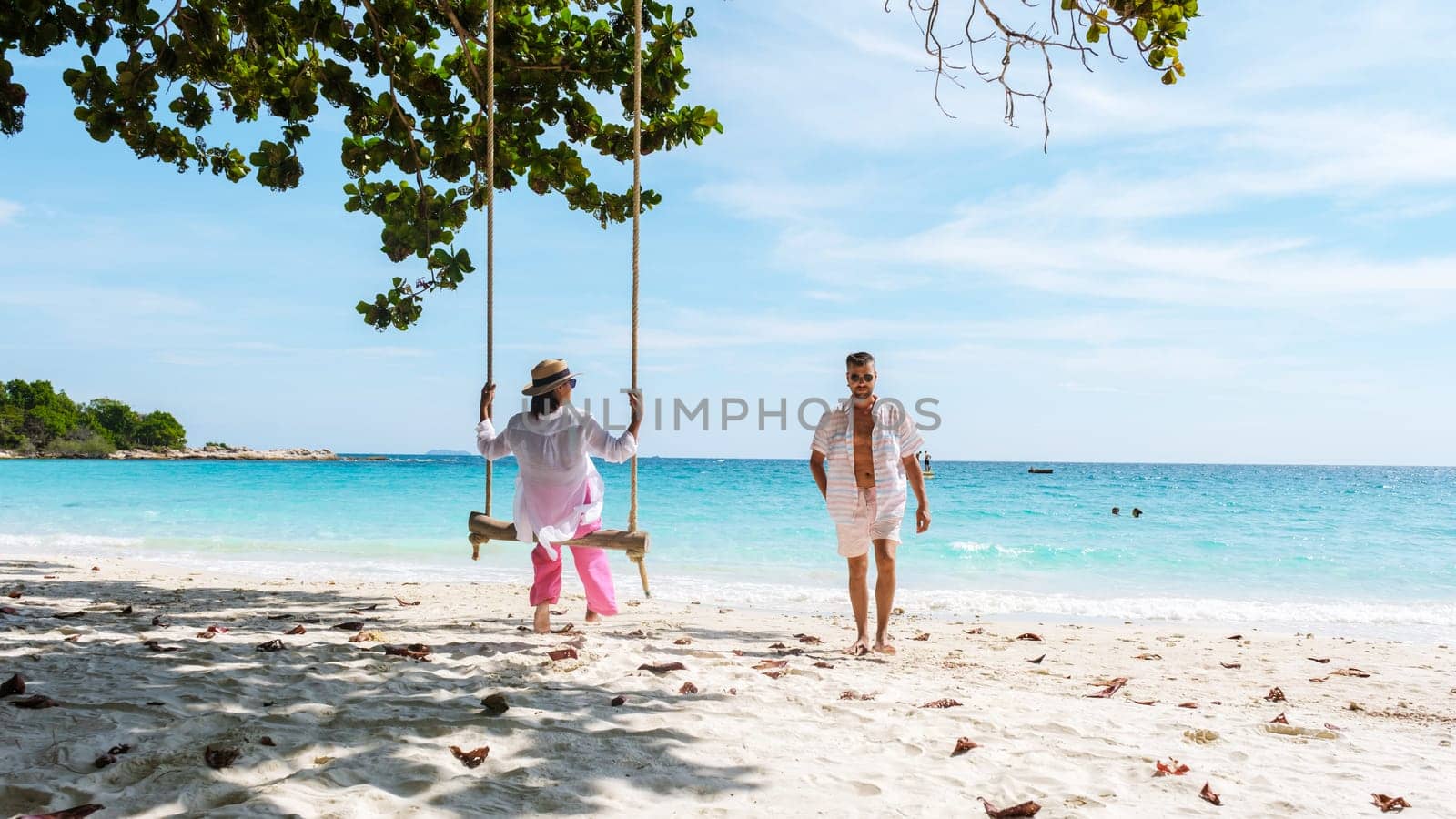 A couple of men and woman at a swing on the beach of Koh Samet Island Rayong Thailand by fokkebok