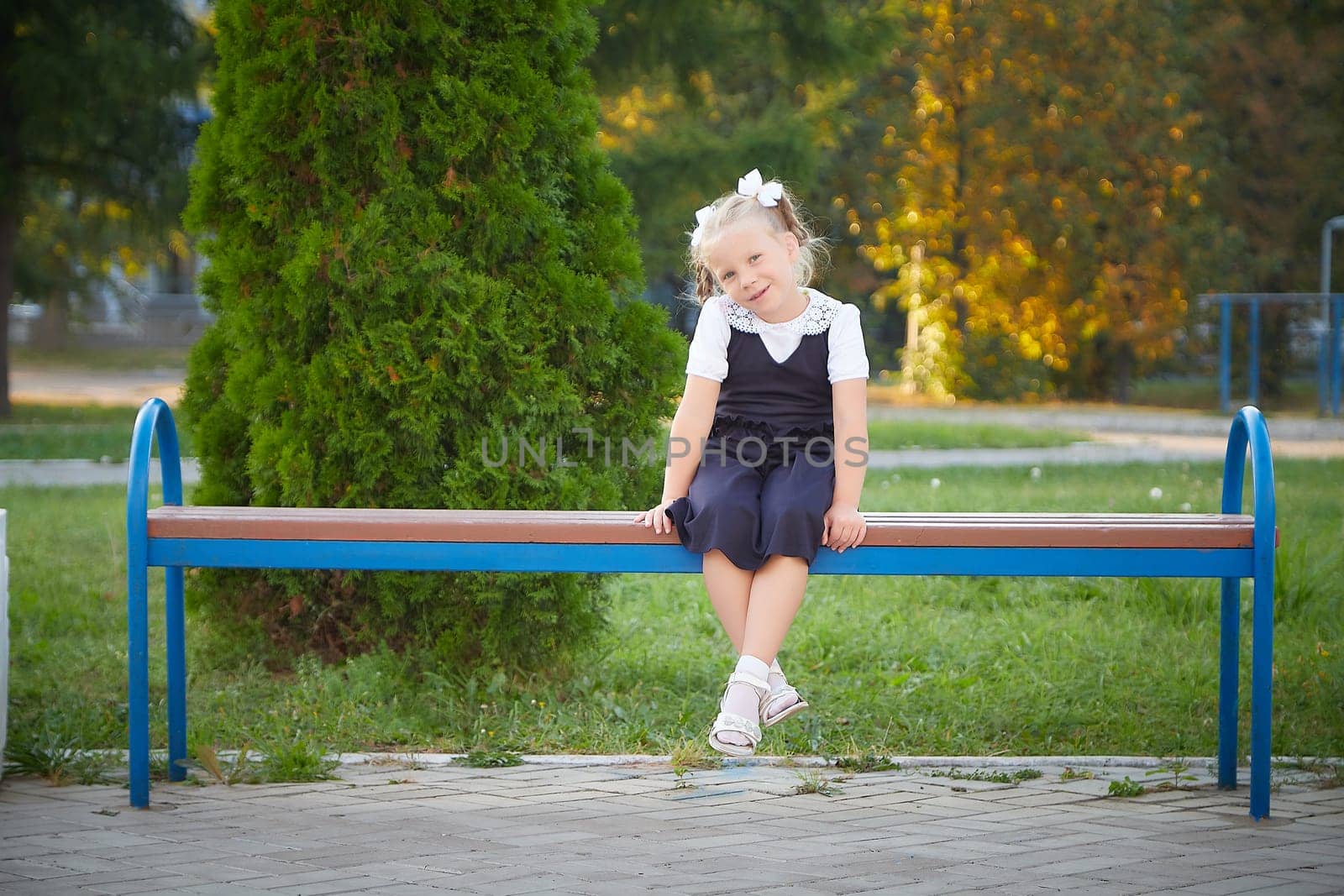 Little girl of elementary school student in modern school uniform outdoors. Female child schoolgirl going to school. Back to school in september 1 in Russia by keleny